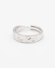 A simple silver ring with a textured surface, displayed against a white background.