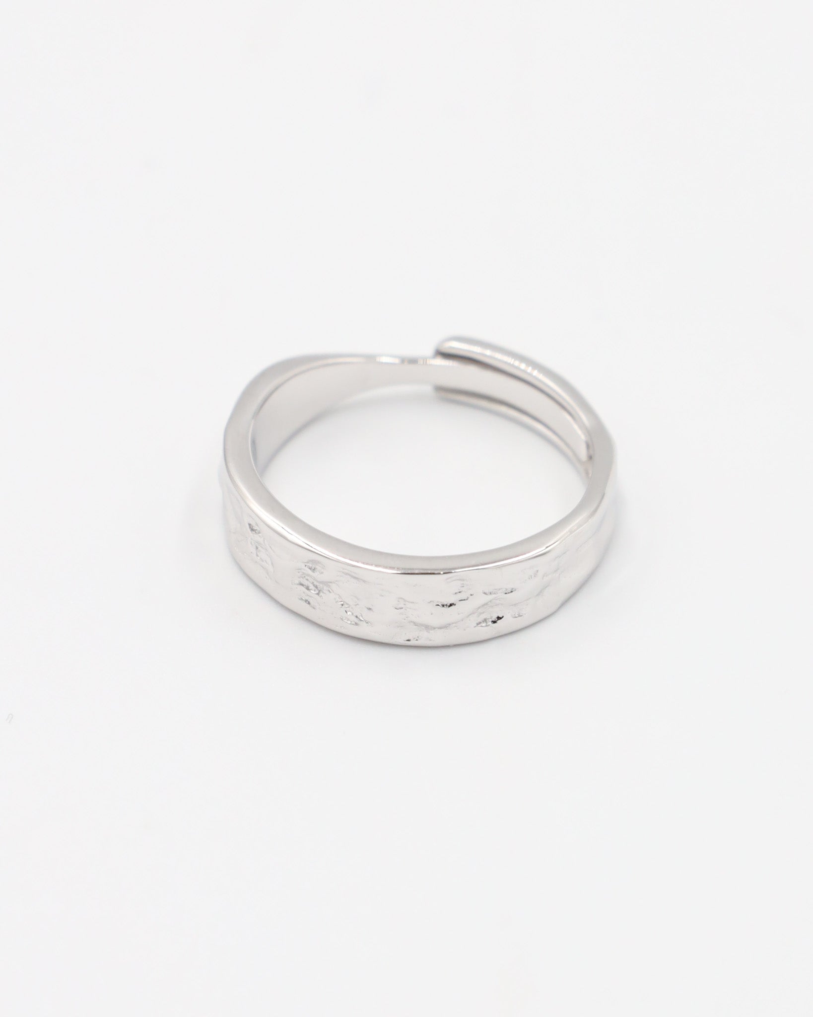 A simple silver ring with a textured surface, displayed against a white background.