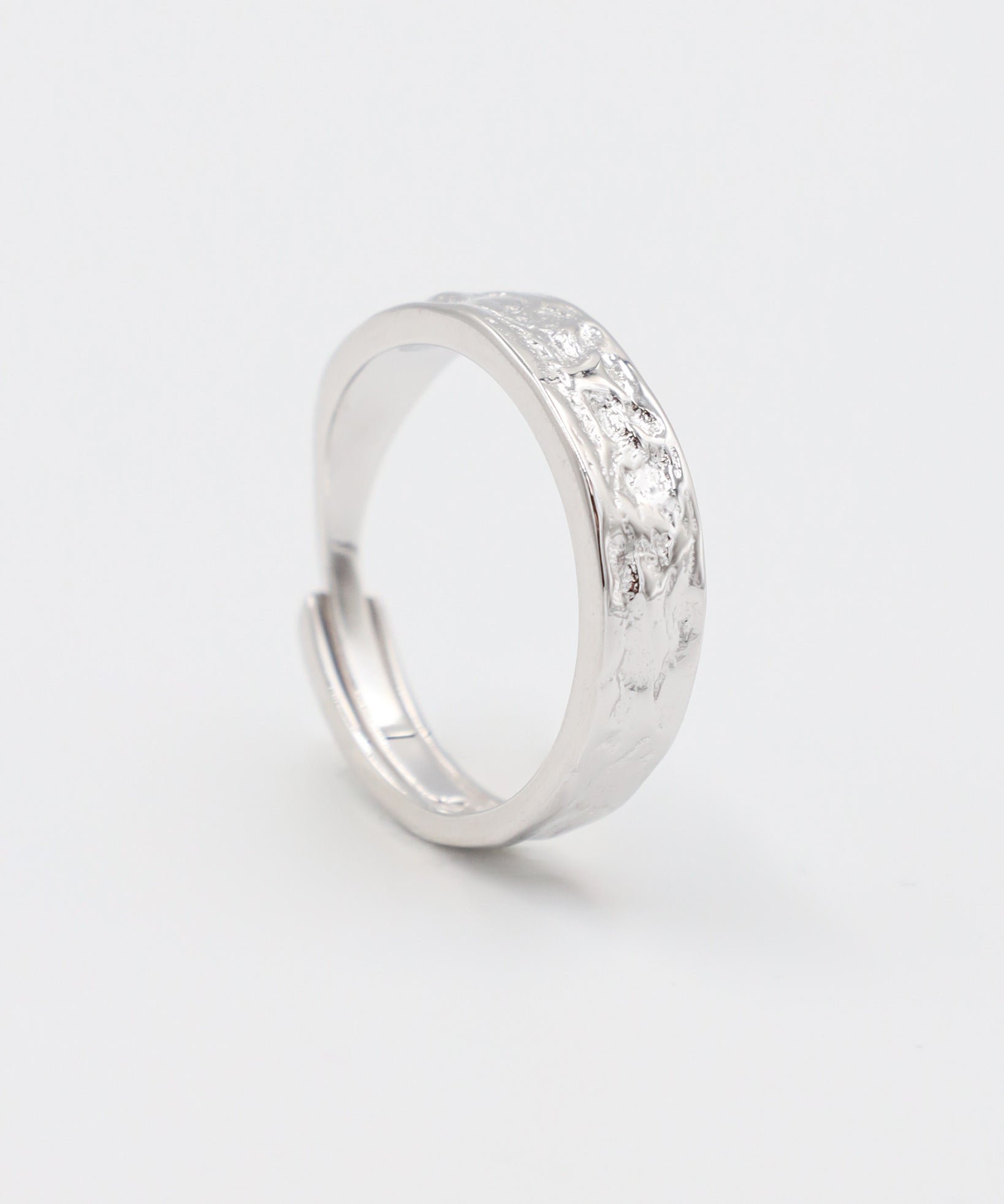 A simple silver ring with a textured surface, displayed against a white background.