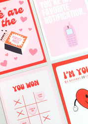 Four playful Valentine’s Day postcards in a bold, pop-art style: one with a matchbox reading “Perfect Match” surrounded by hearts, one saying “You’re my favorite notification” with a retro mobile phone, one with “You won” and a Tic-Tac-Toe layout using candy hearts, and one featuring a smiling heart with the phrase “I’m yours – no refunds.” 