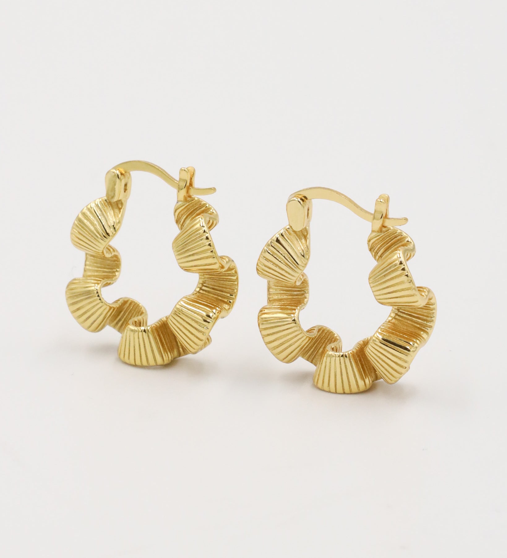A pair of gold creoles earrings with a latch back clasp.