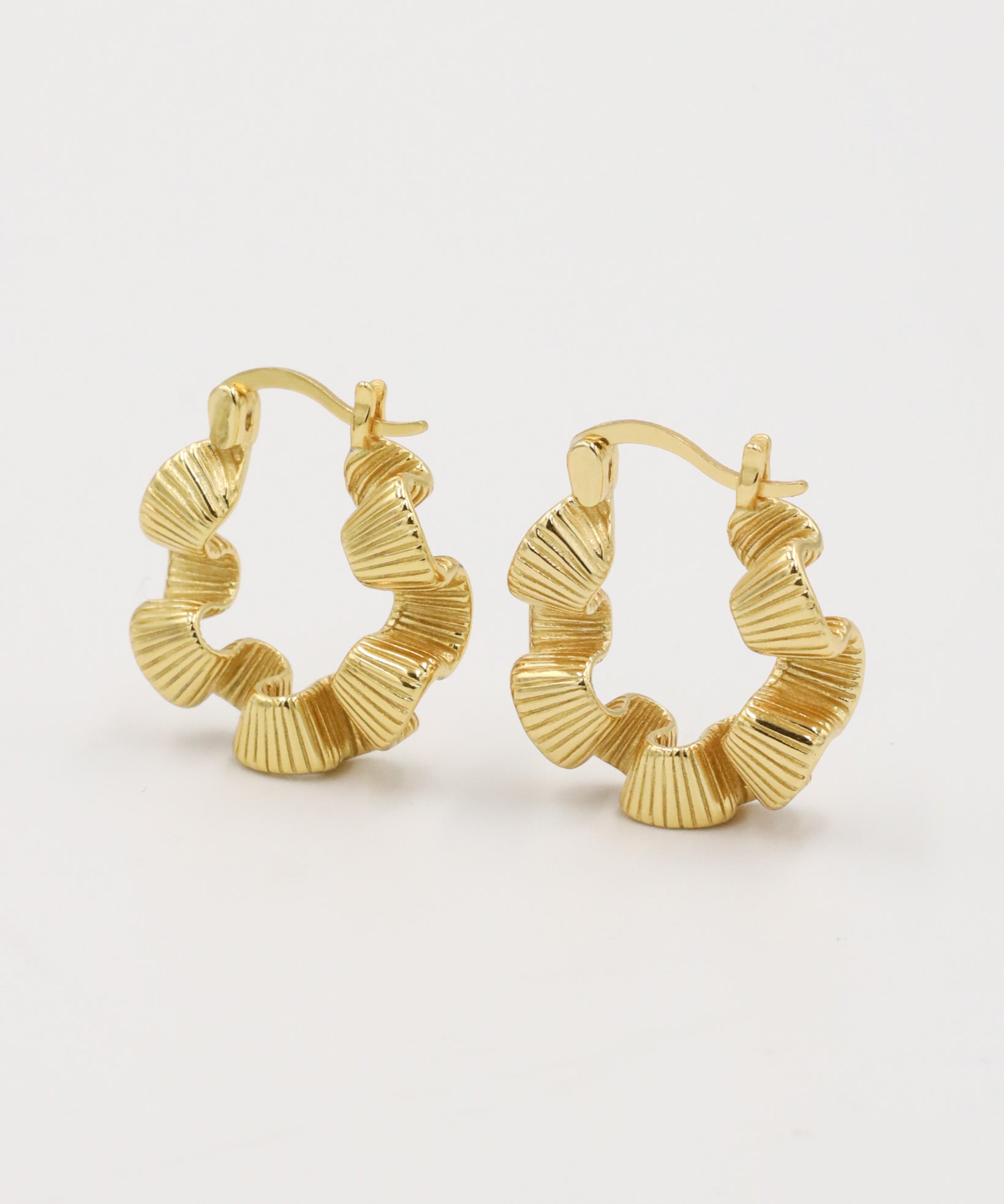 A pair of gold creoles earrings with a latch back clasp.