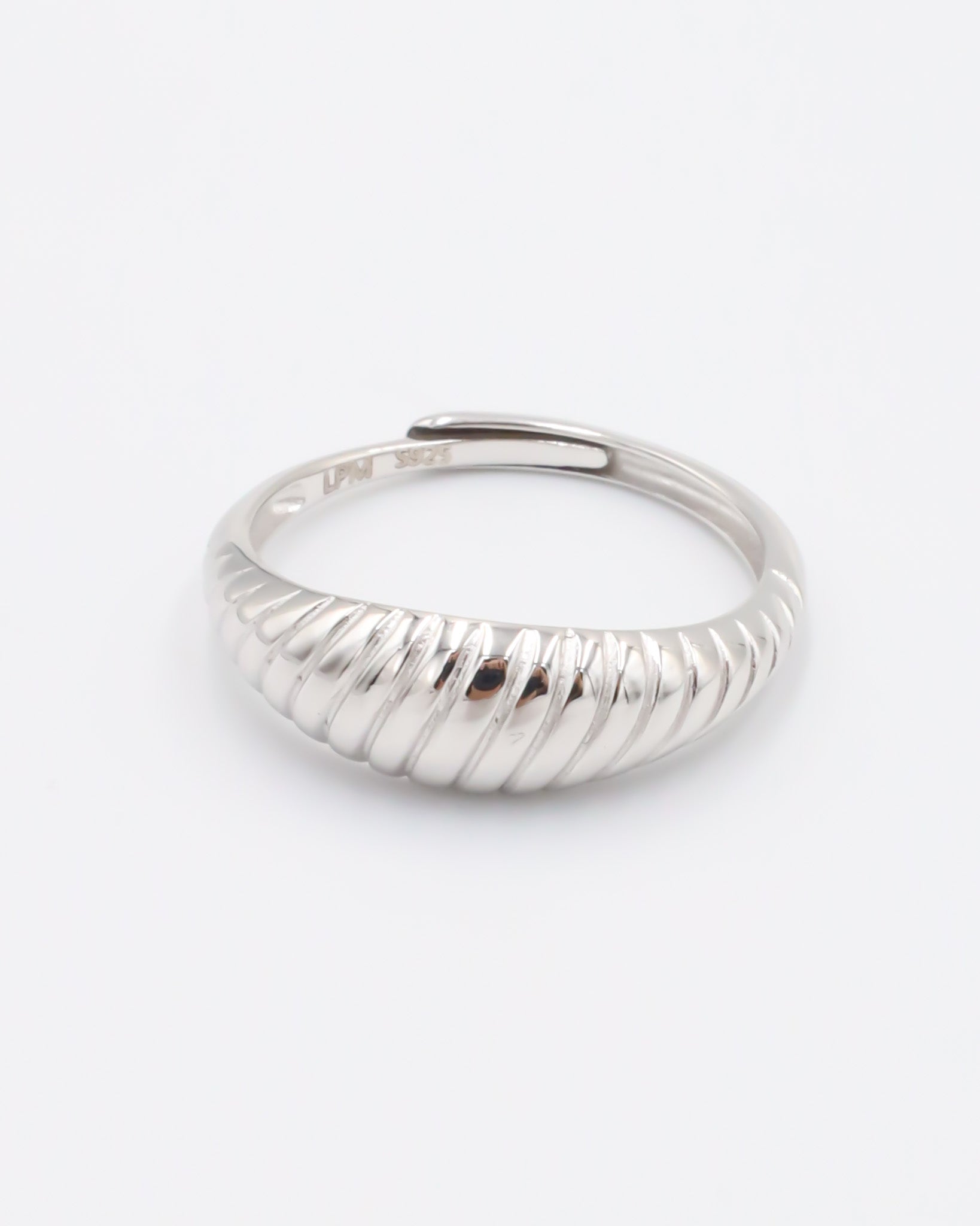 A single silver ring with a textured band on a white background.