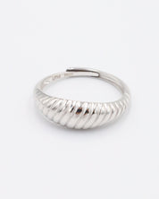 A single silver ring with a textured band on a white background.