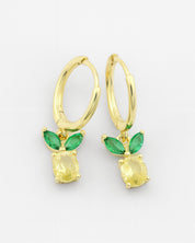 Gold earrings with green gemstones on a white background