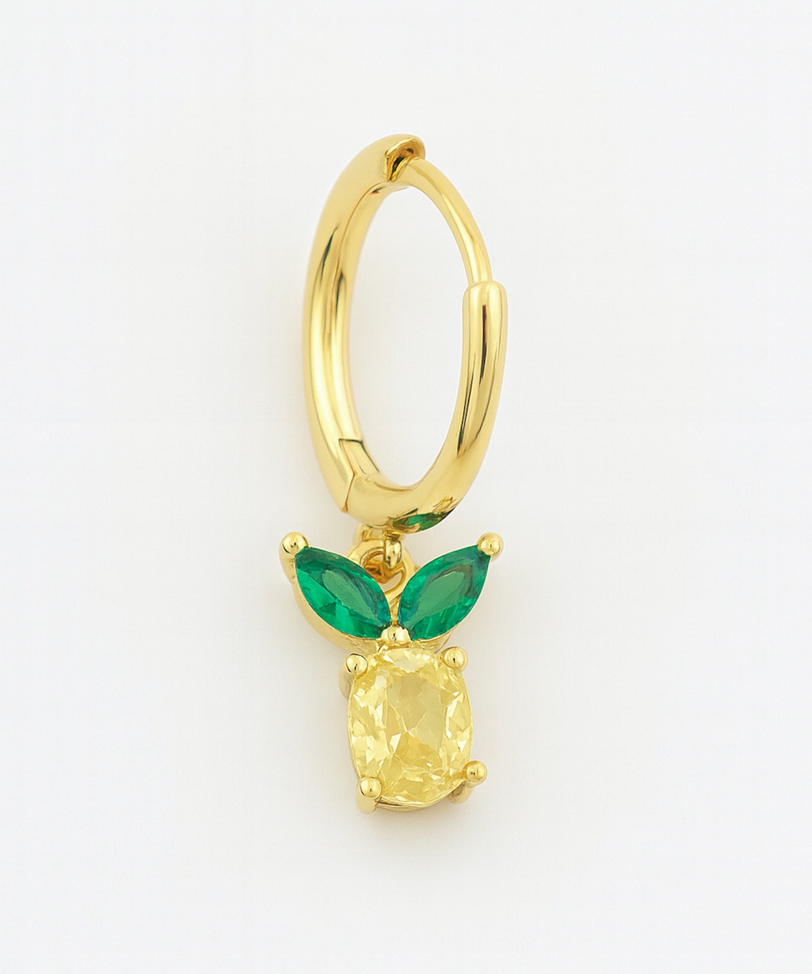 Gold hoop earring with green gemstones on a white background