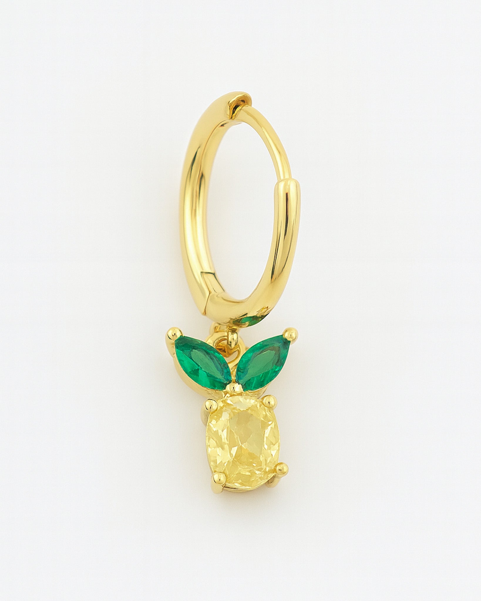 Gold hoop earring with green gemstones on a white background