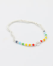 Adjustable sterling silver Pietro bracelet featuring a smiley charm and colorful accent beads, angled view.