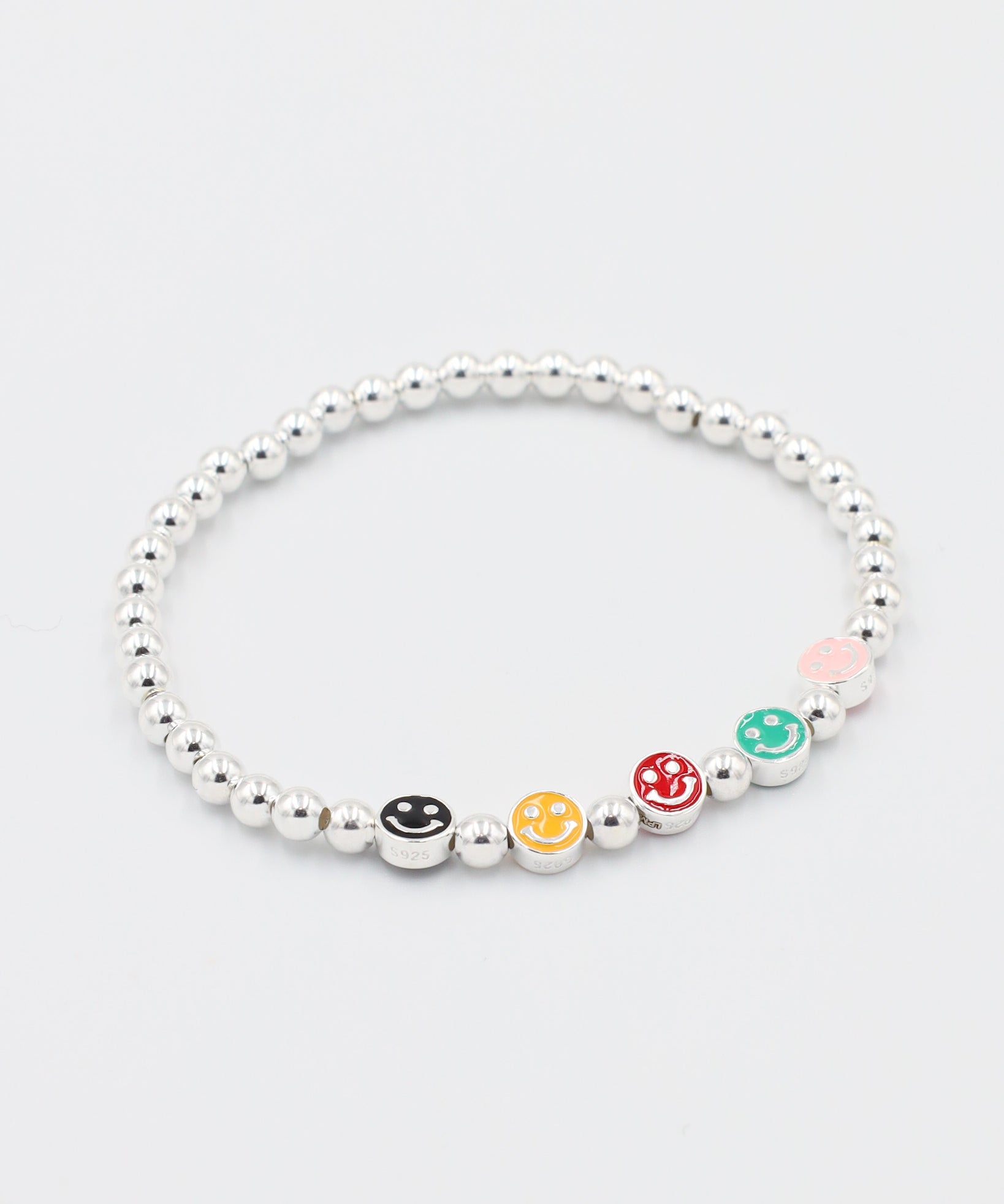 Angled view of adjustable sterling silver bracelet featuring multi-colored smiley face beads and round silver beads.