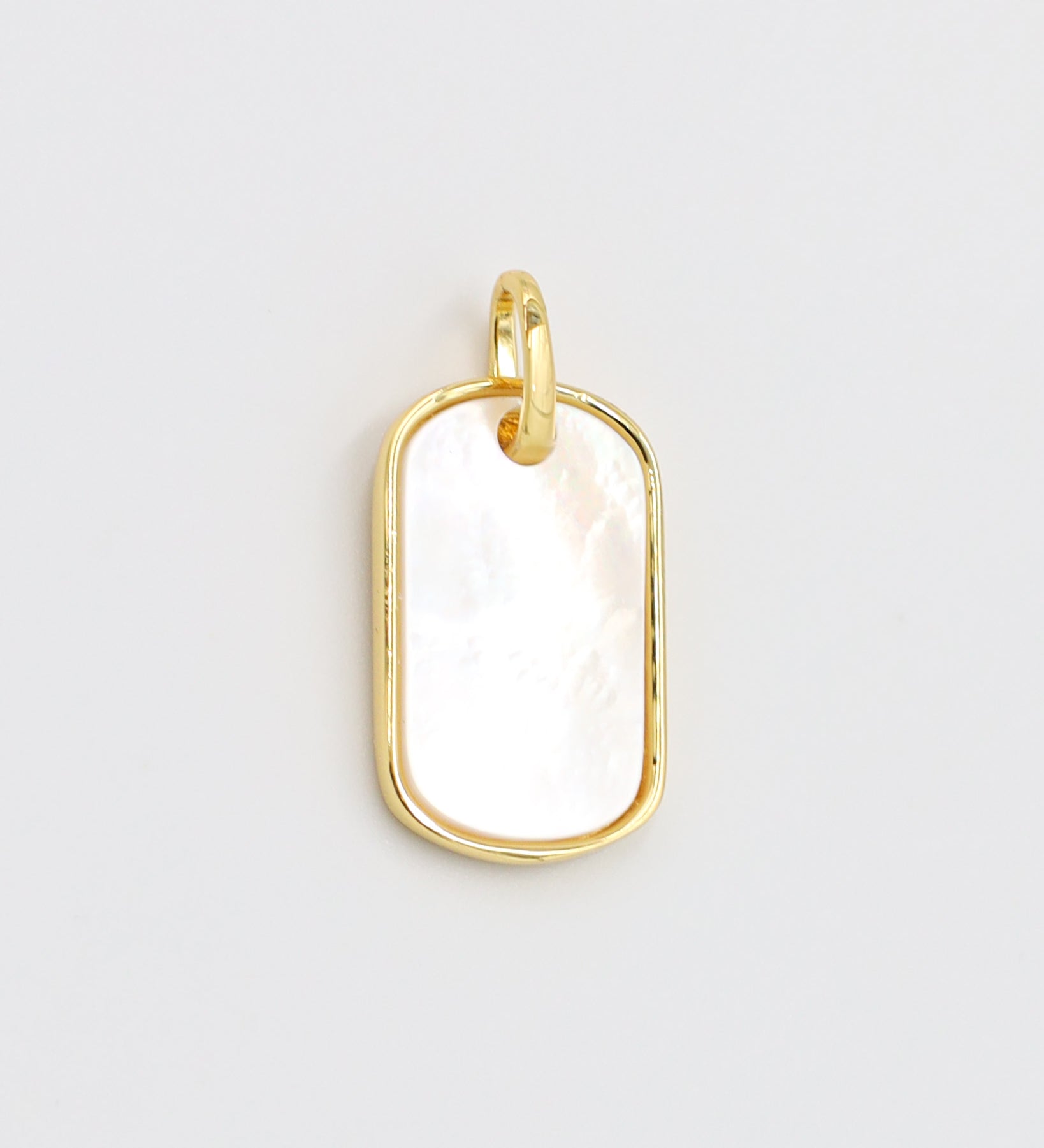 Close-up view of the Amara pendant in gold-plated 925 sterling silver with a white enamel surface.