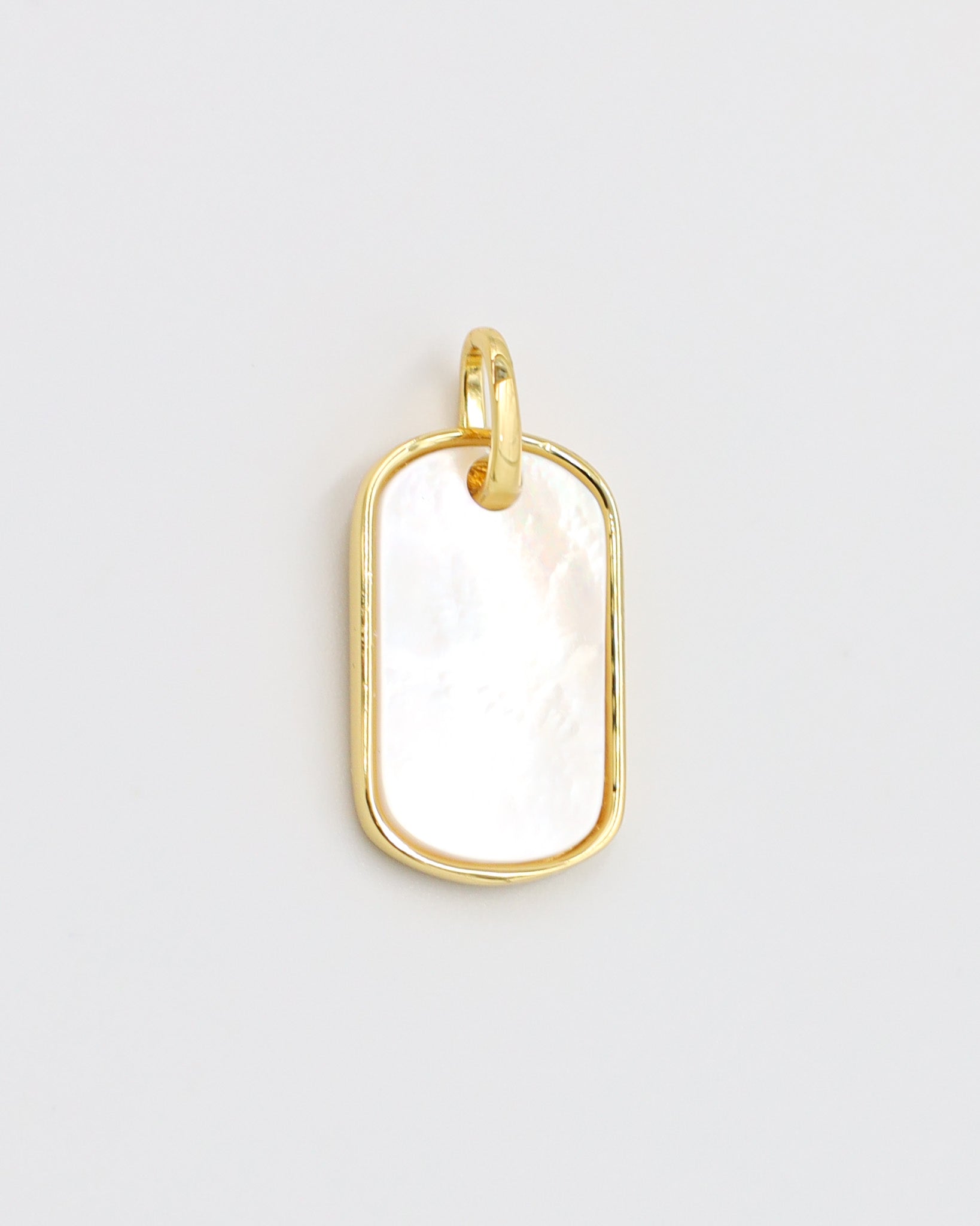 Close-up view of the Amara pendant in gold-plated 925 sterling silver with a white enamel surface.