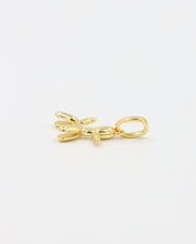 Side view of a gold-plated sterling silver balloon dog pendant.
