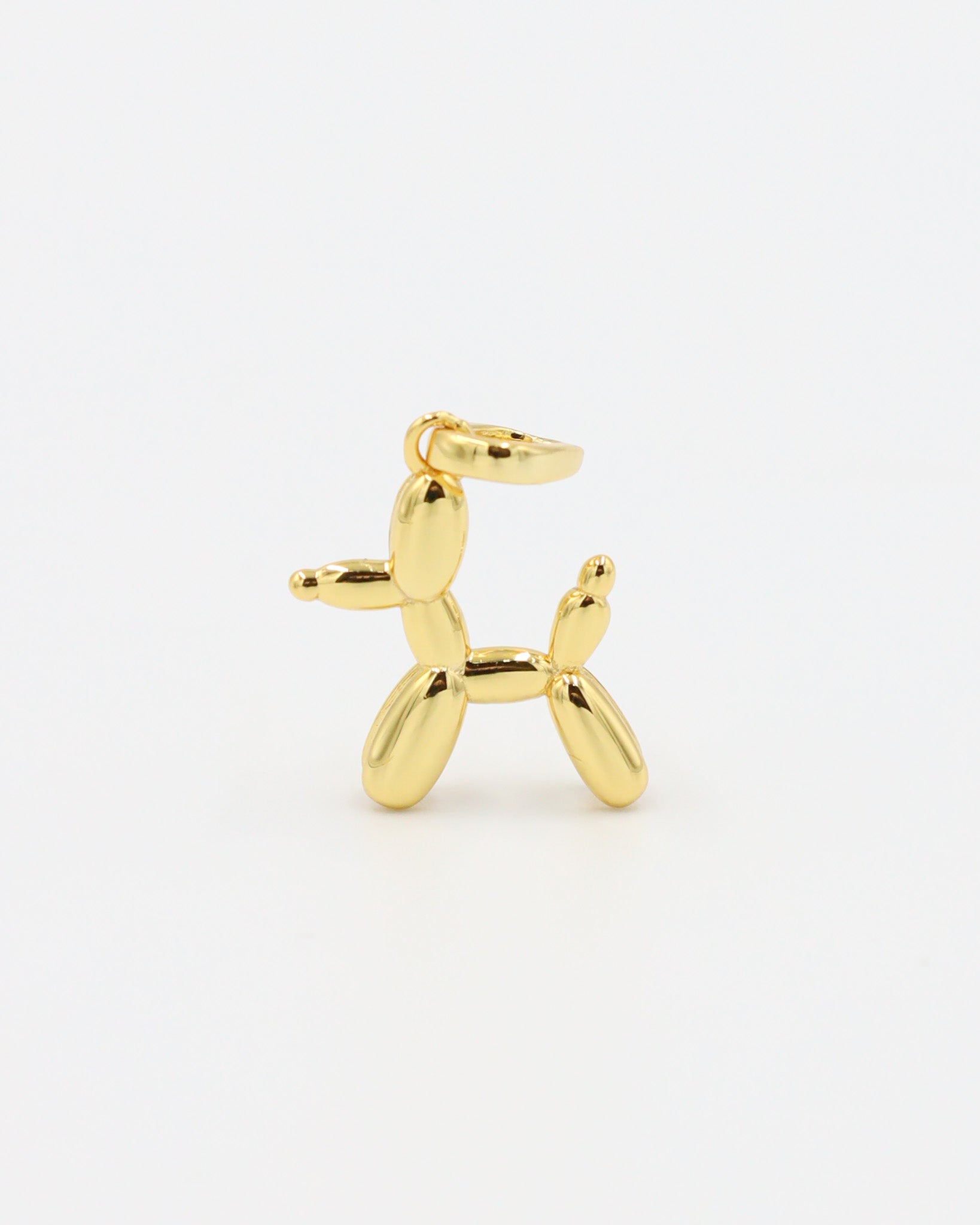 Standing view of a gold-plated balloon dog pendant made from sterling silver.
