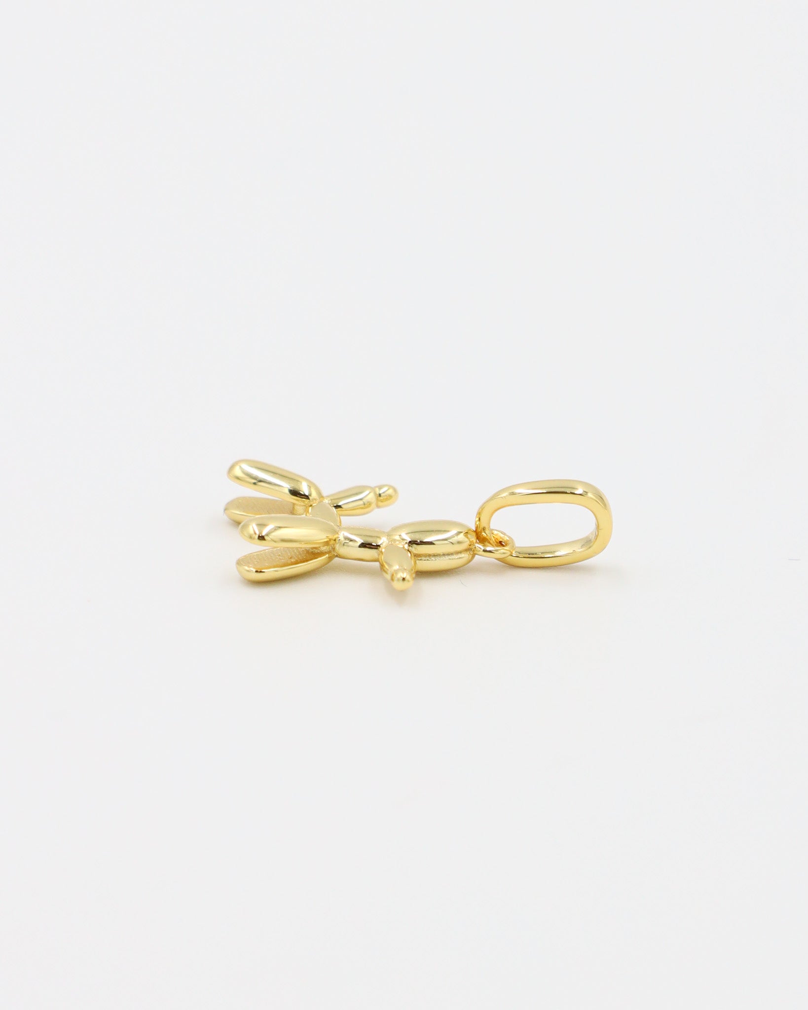Side view of a gold-plated sterling silver balloon dog pendant.

