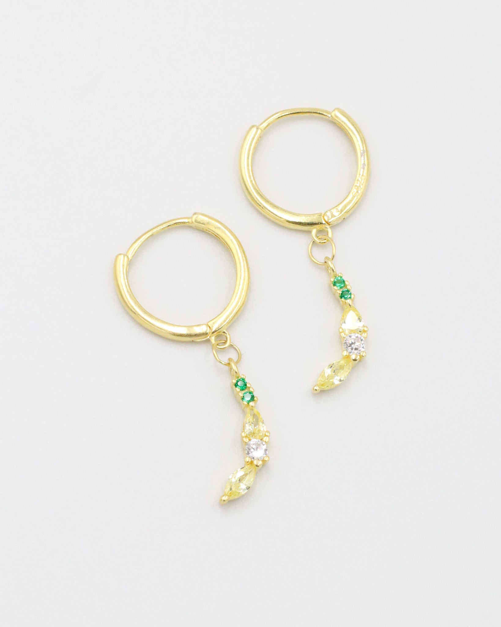 A pair of banana-shaped gold-plated sterling silver earrings adorned with yellow and green zirconia stones.