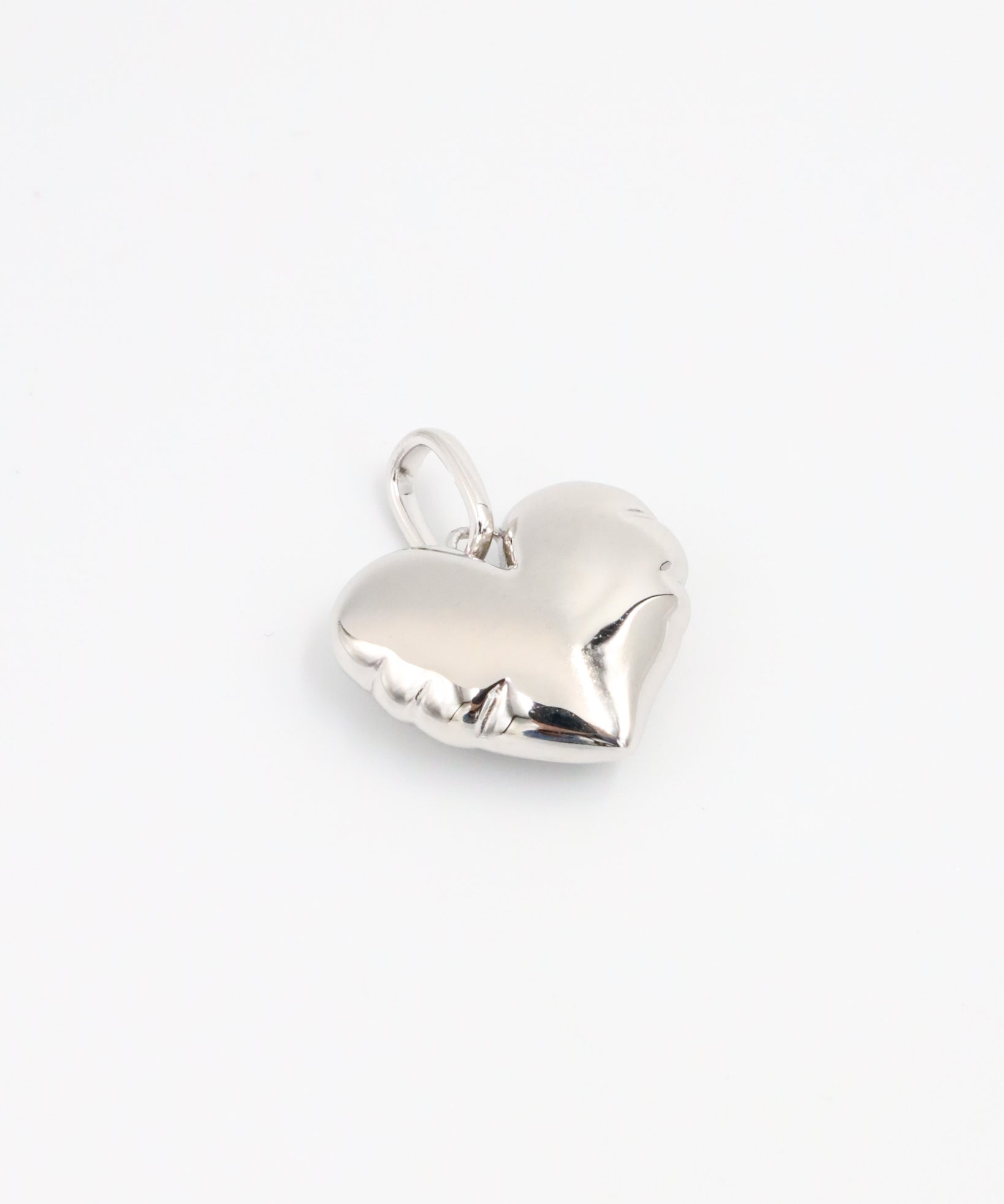 Side view of the Bella Silver heart pendant, showcasing its smooth, sculpted surface in rhodium-plated 925 sterling silver.