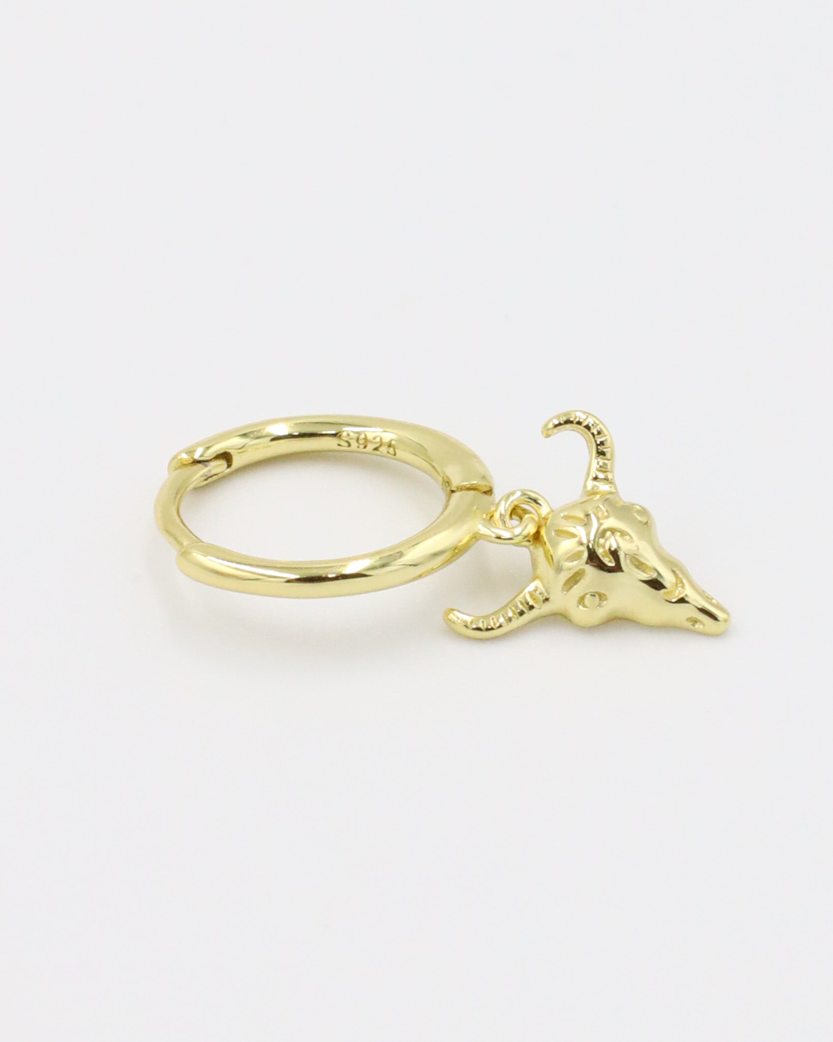 A single gold-plated sterling silver hoop earring with a bull skull charm.