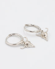 Pair of sterling silver hoop earrings with detailed bull skull charms.