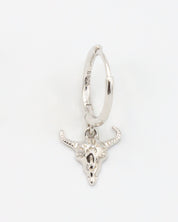 Close-up of a sterling silver hoop earring featuring a detailed bull skull charm, front view.