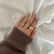 Daphne - adjustable gold-plated sterling silver ring with wavy texture, worn on hand, minimalist design.