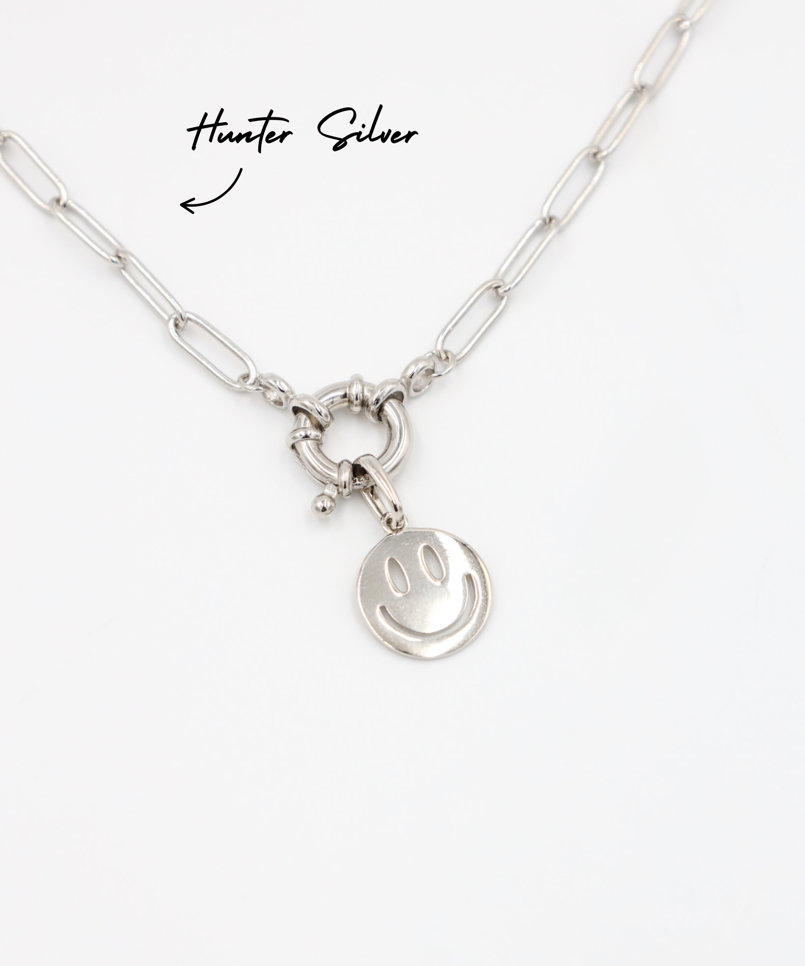 Flynn Silver smiley face pendant hanging on the Hunter Silver chain, both made of rhodium-plated 925 sterling silver.