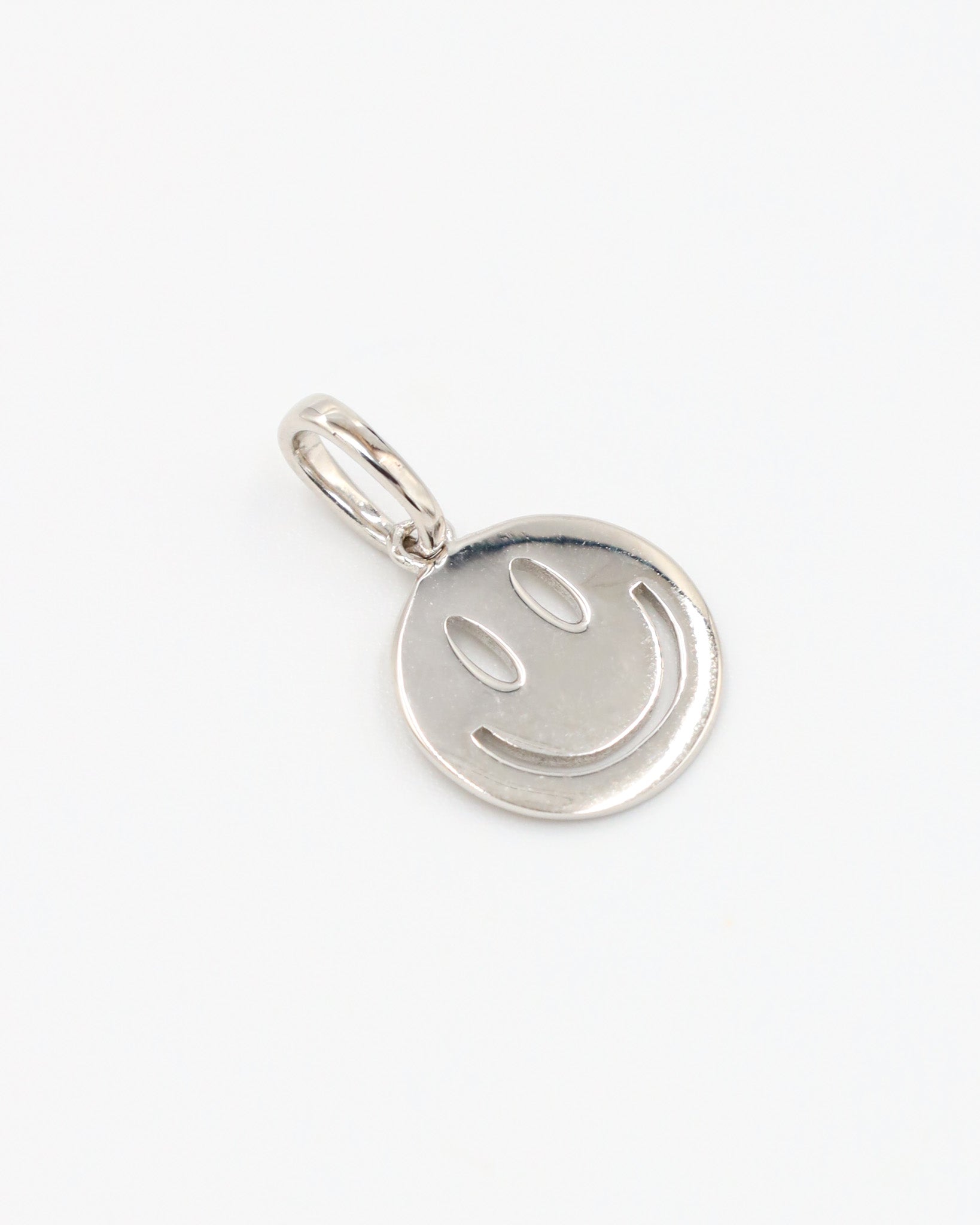 Flynn Silver pendant, a smiley face design crafted from rhodium-plated 925 sterling silver, displayed at an angle.