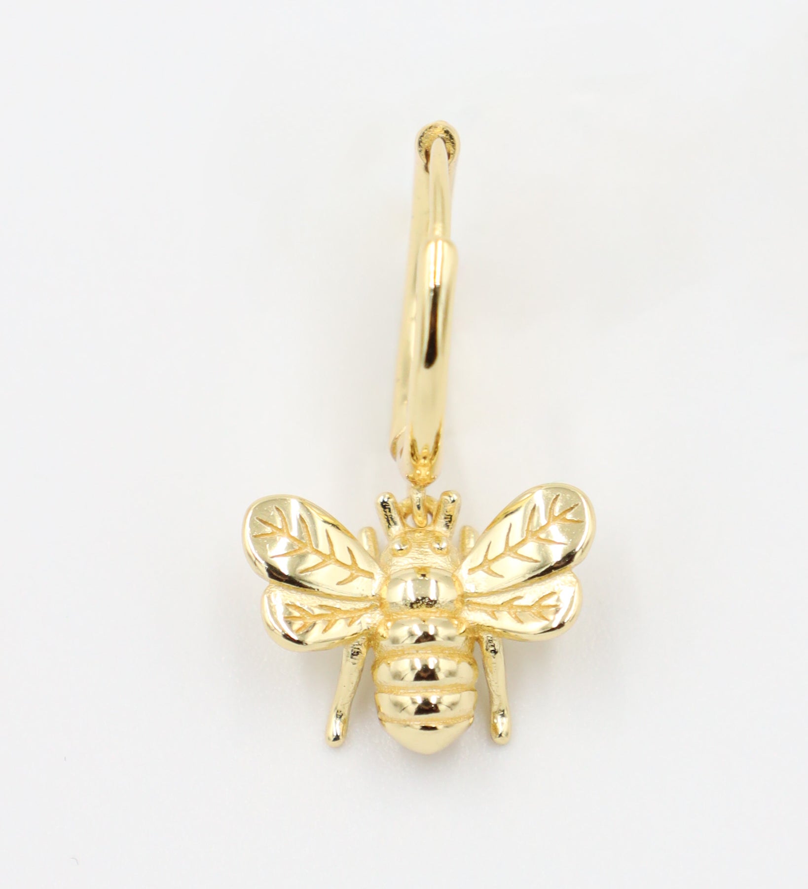 Single gold-plated sterling silver hoop earring featuring a detailed bee charm, front view.