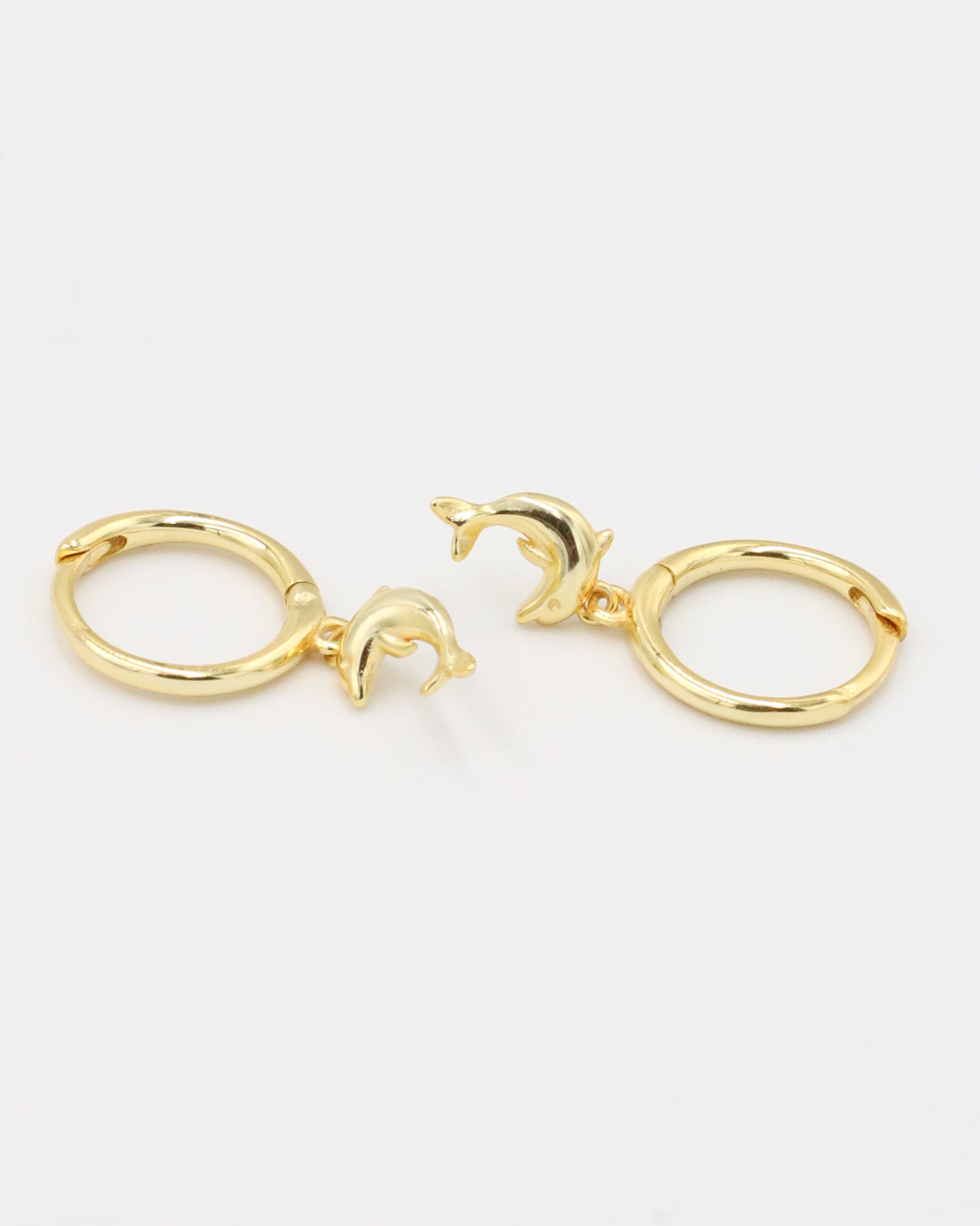 Pair of gold-plated sterling silver hoop earrings with dolphin charms, front view.
