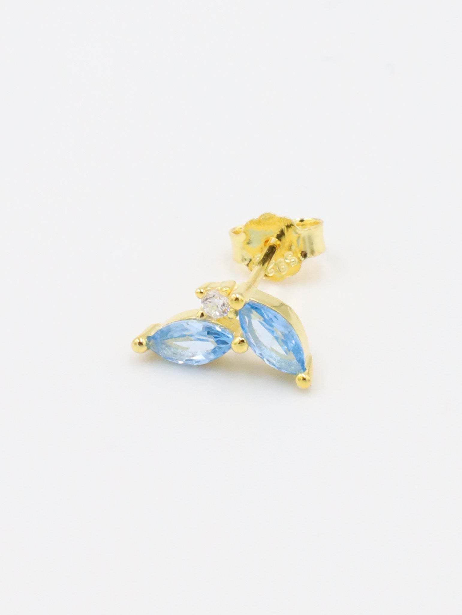 Left ear gold-plated sterling silver stud earring showcasing two blue zirconia stones in a marquise cut with a central round zirconia stone.