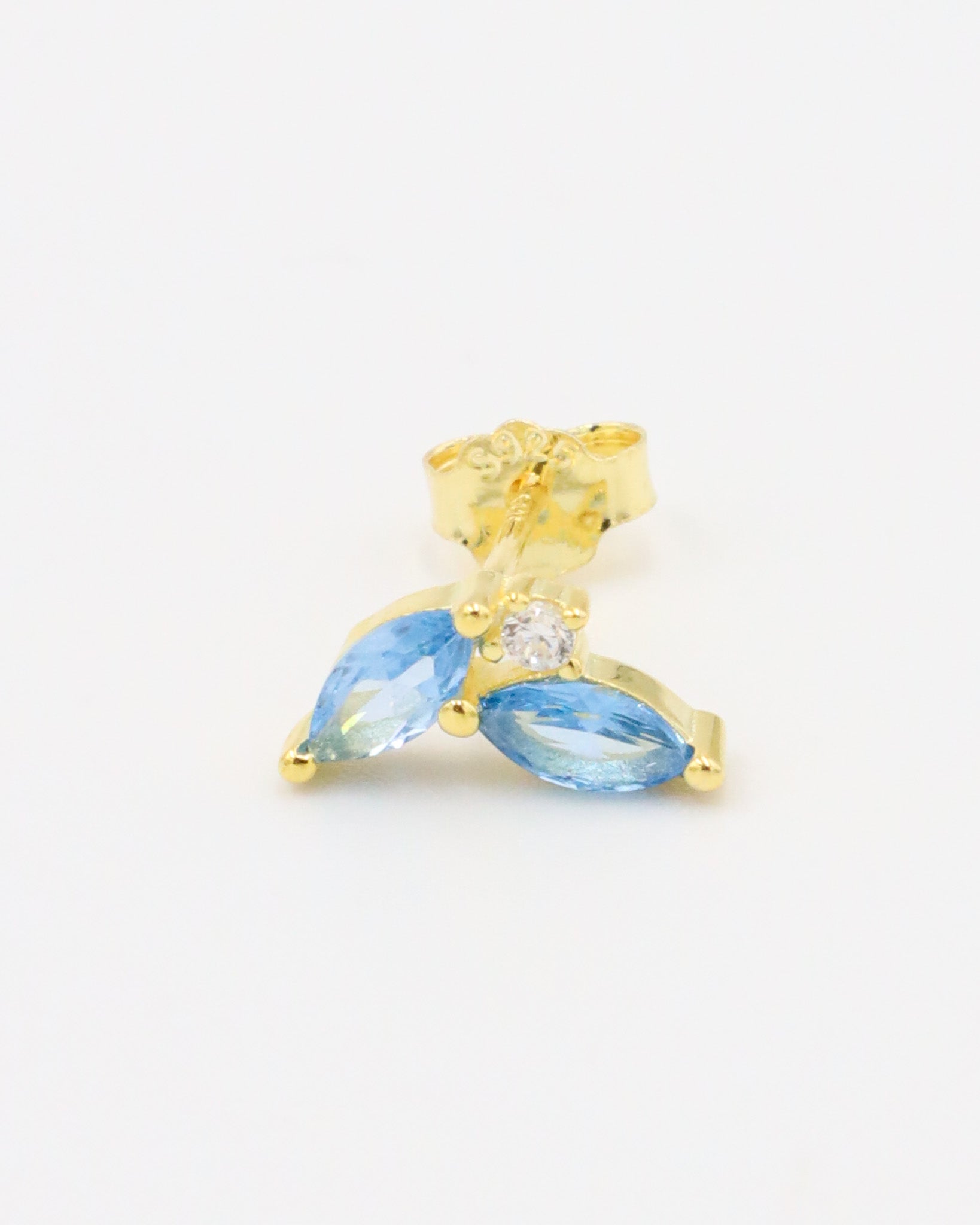 Right ear gold-plated sterling silver stud earring featuring two marquise-cut blue zirconia stones and a central round zirconia stone.