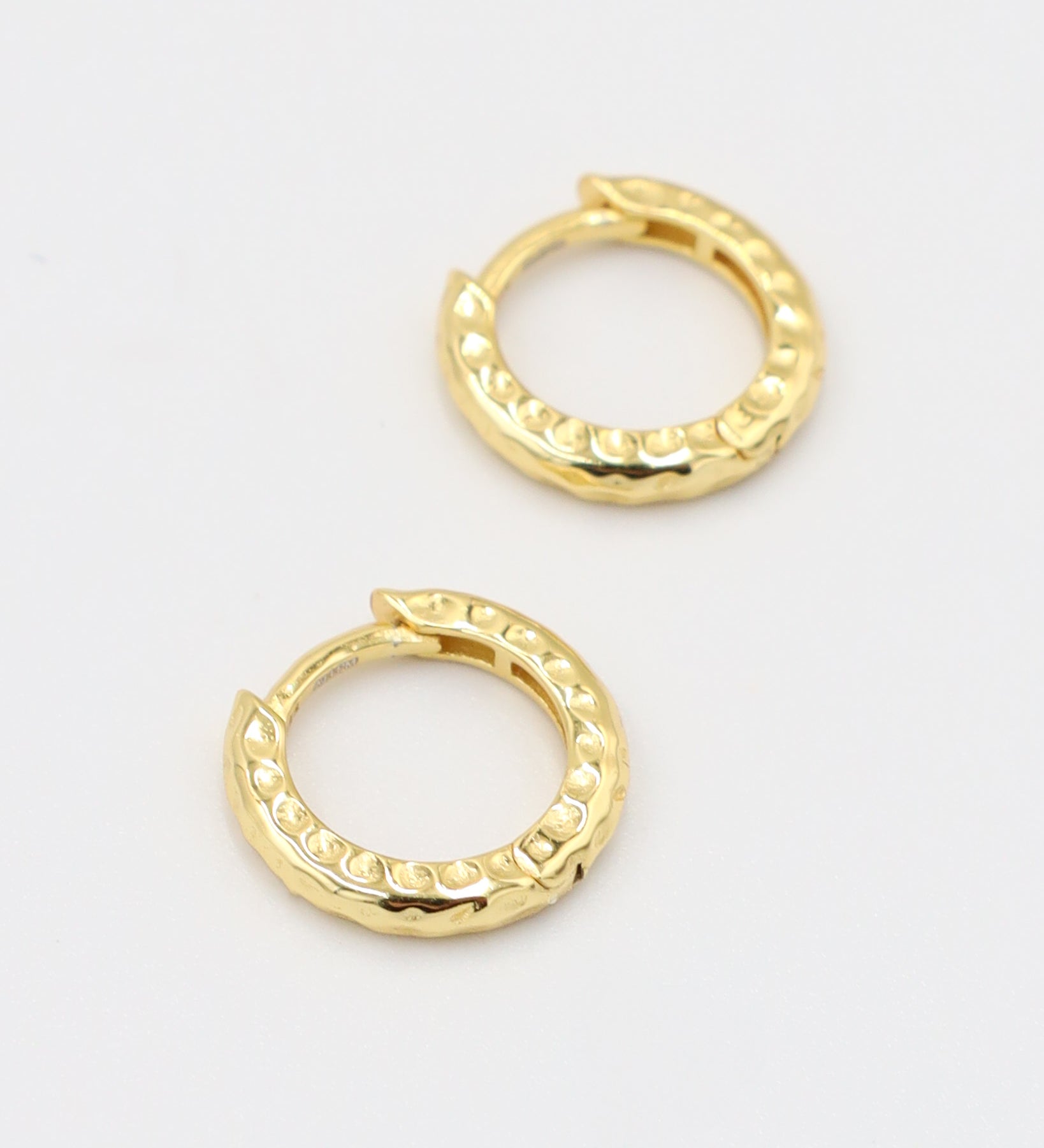 Gold-plated sterling silver Siranush huggie earrings, shown as a pair, featuring a textured design.