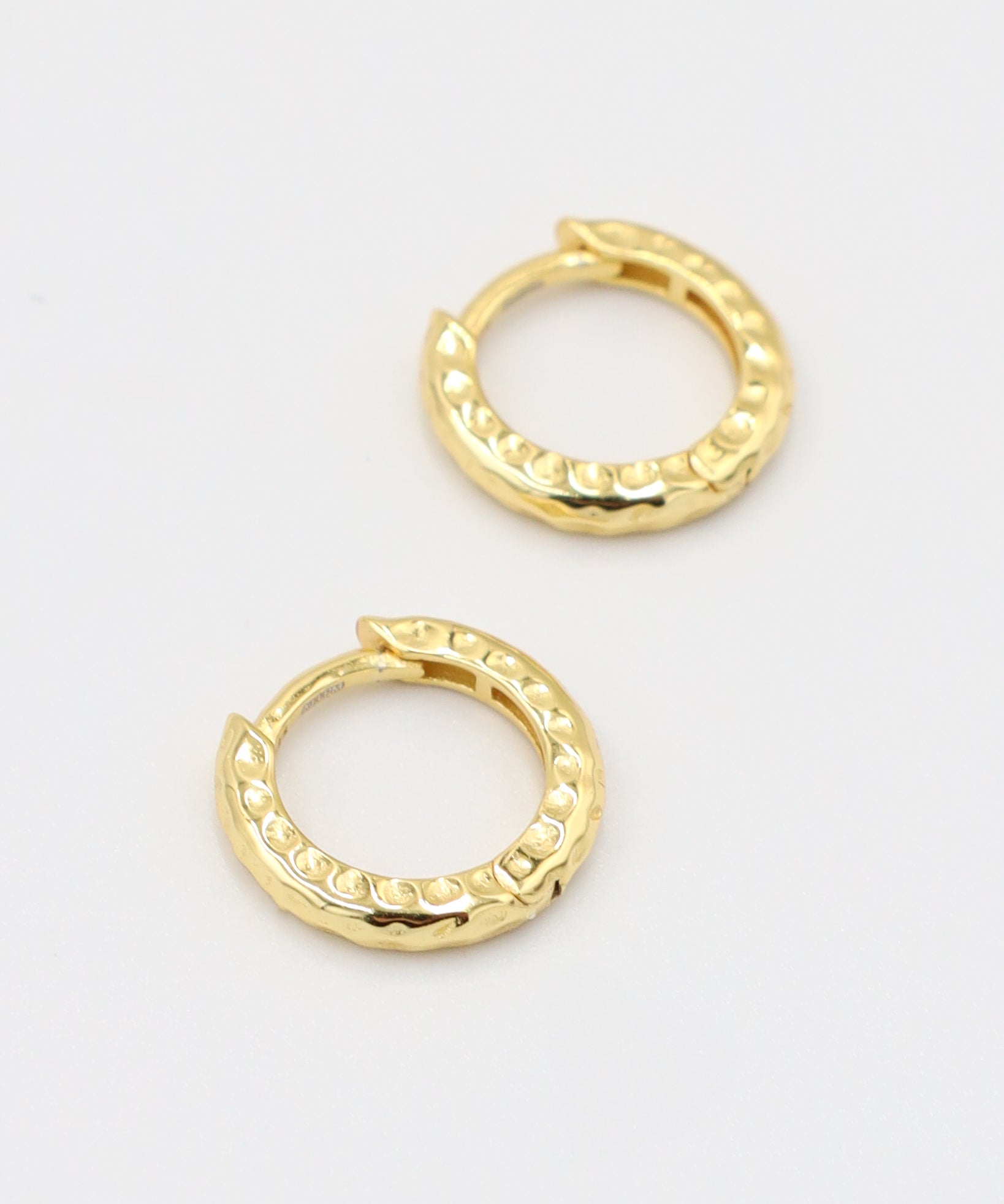 Gold-plated sterling silver Siranush huggie earrings, shown as a pair, featuring a textured design.