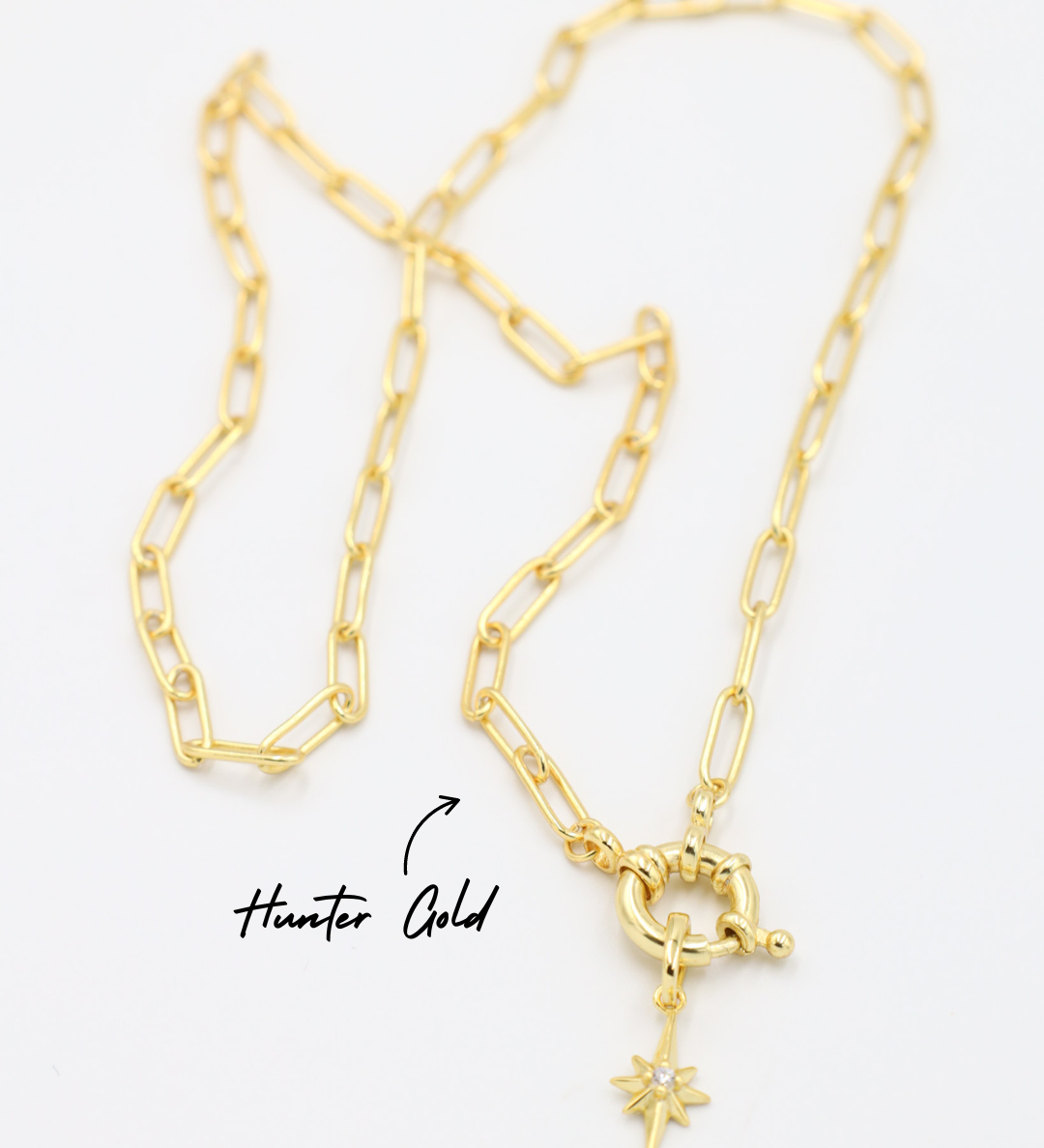 Gold star-shaped pendant with a zirconia stone, paired with a chain necklace.