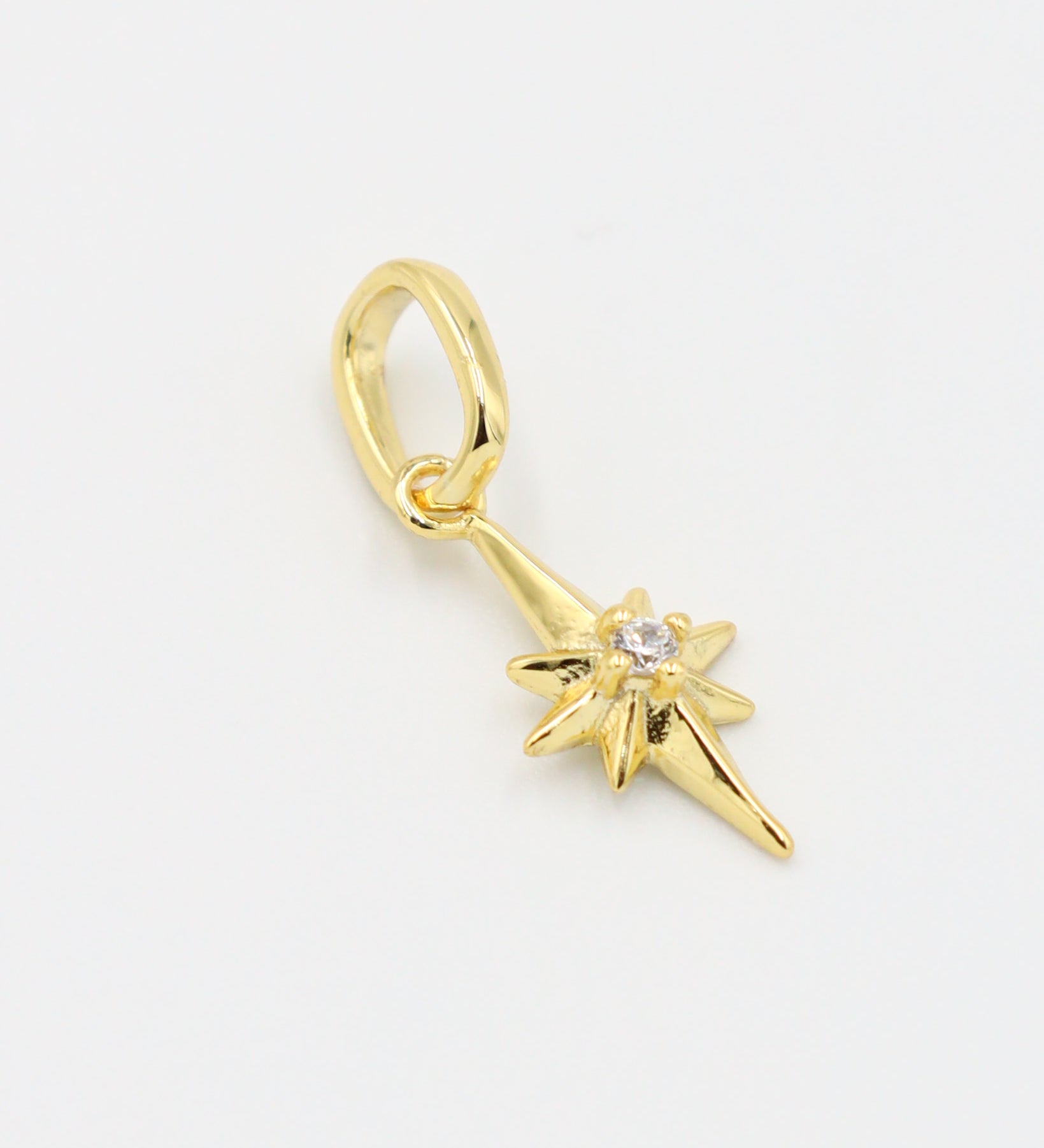 Close-up of a gold star pendant, showcasing the zirconia stone centerpiece.