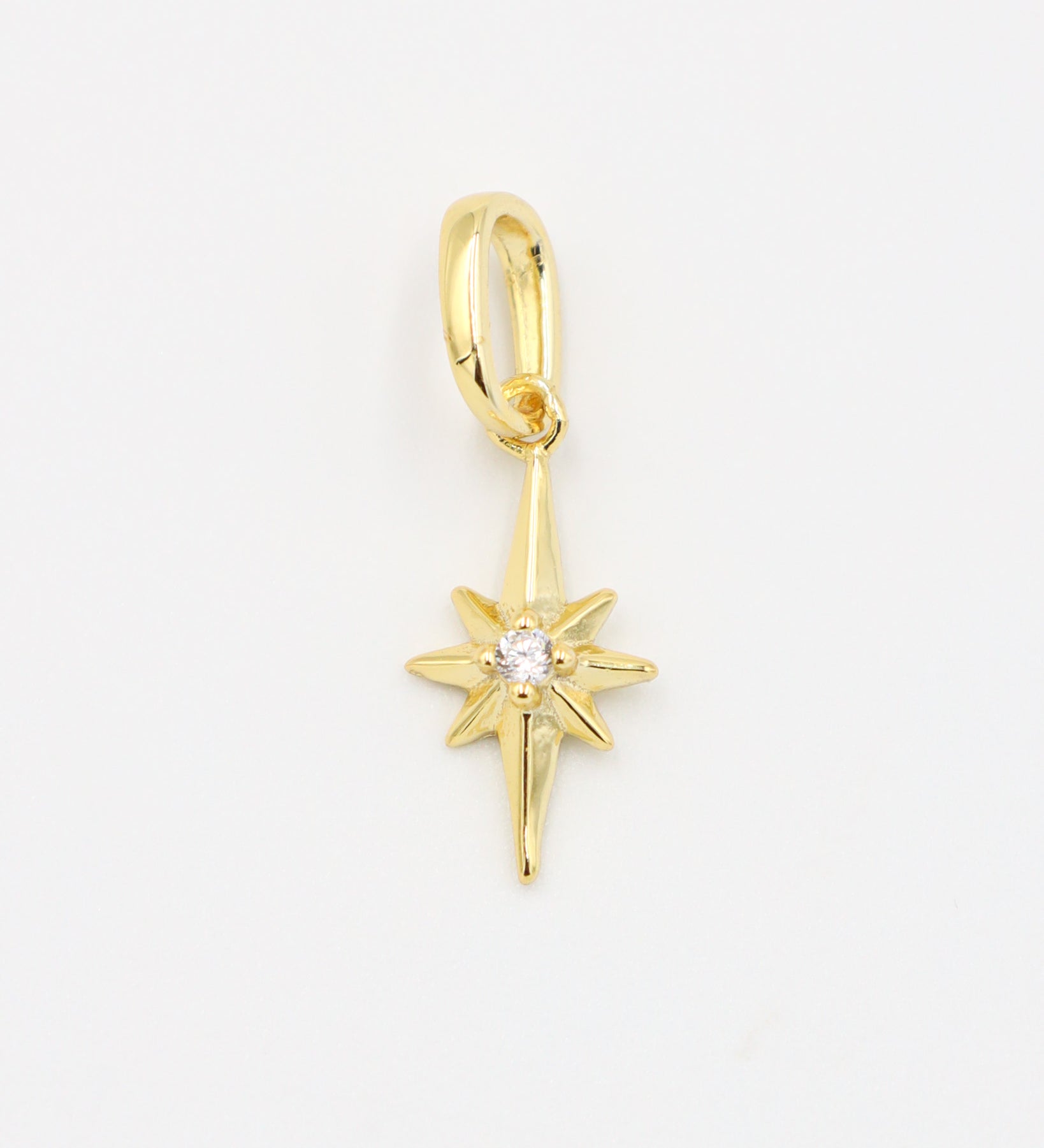 Gold star pendant with a sparkling zirconia stone on a smooth gold finish.