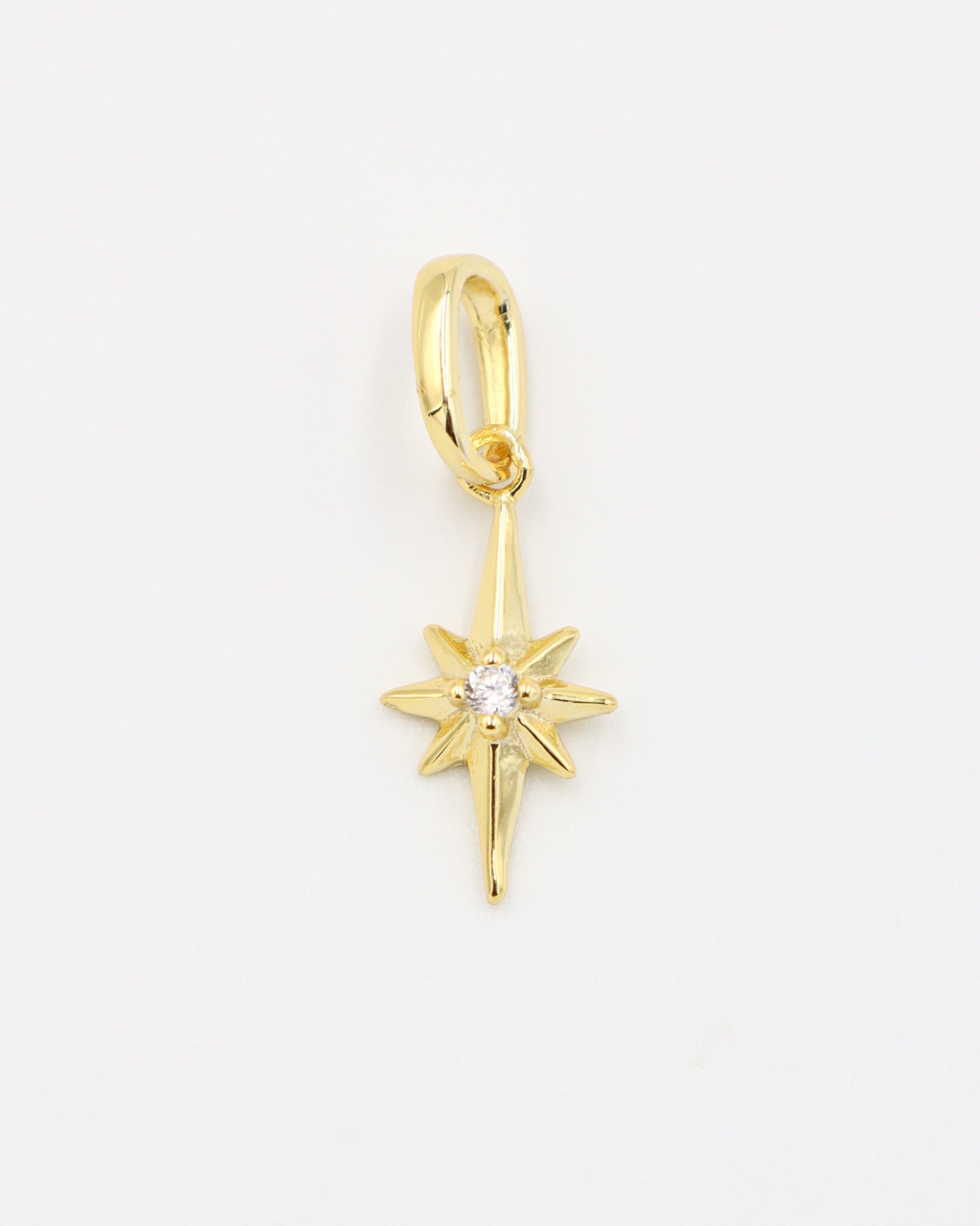 Gold star pendant with a sparkling zirconia stone on a smooth gold finish.
