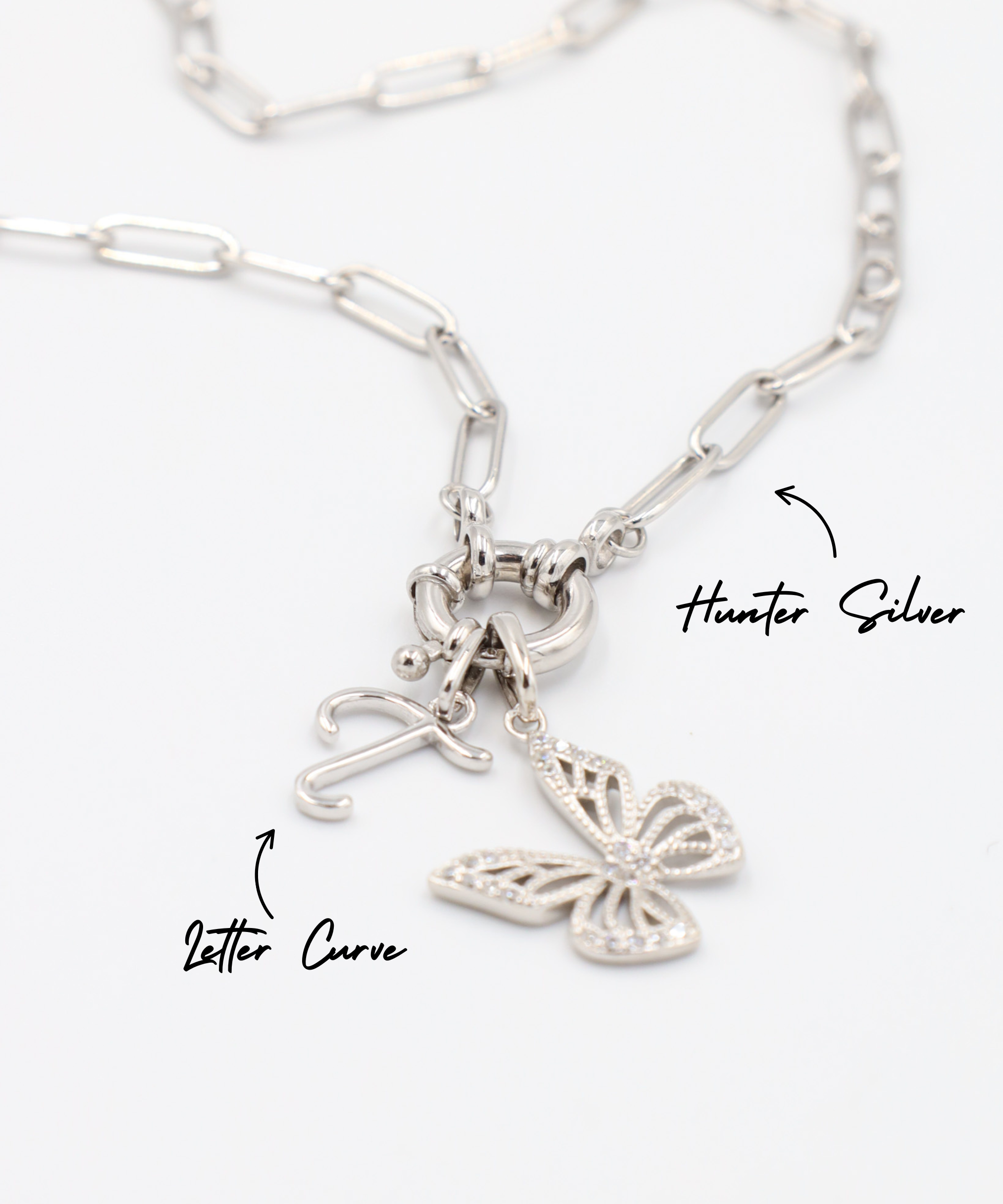 Hunter Silver necklace featuring a Butterfly Silver pendant and a letter curve charm, both in rhodium-plated 925 sterling silver.