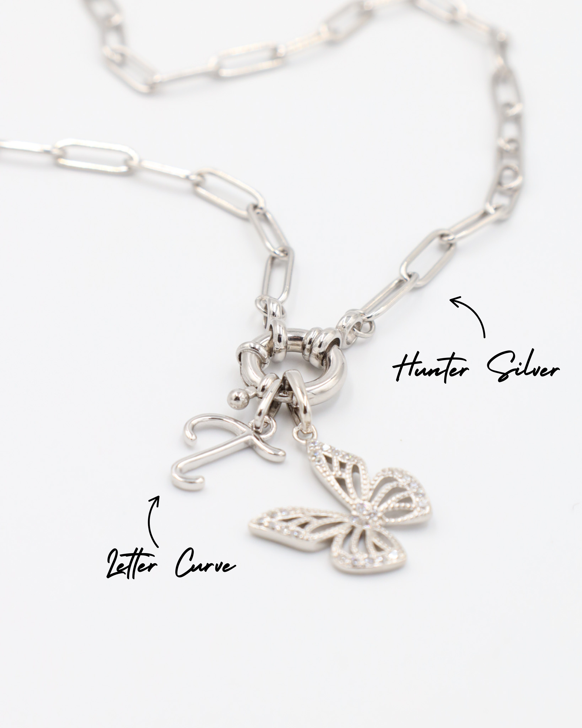 Hunter Silver necklace featuring a Butterfly Silver pendant and a letter curve charm, both in rhodium-plated 925 sterling silver.