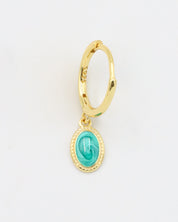 A close-up of a single gold-plated sterling silver hoop earring with an oval turquoise charm, displayed from the front.
