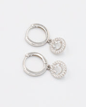 A pair of sterling silver hoop earrings with smiley face pendants paved with zirconia stones.