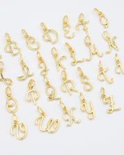 Gold-plated letter curve alphabet pendants arranged neatly for display.