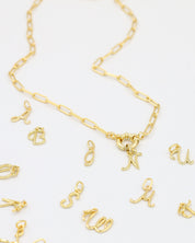 Gold-plated letter curve pendants displayed with a matching gold chain necklace.