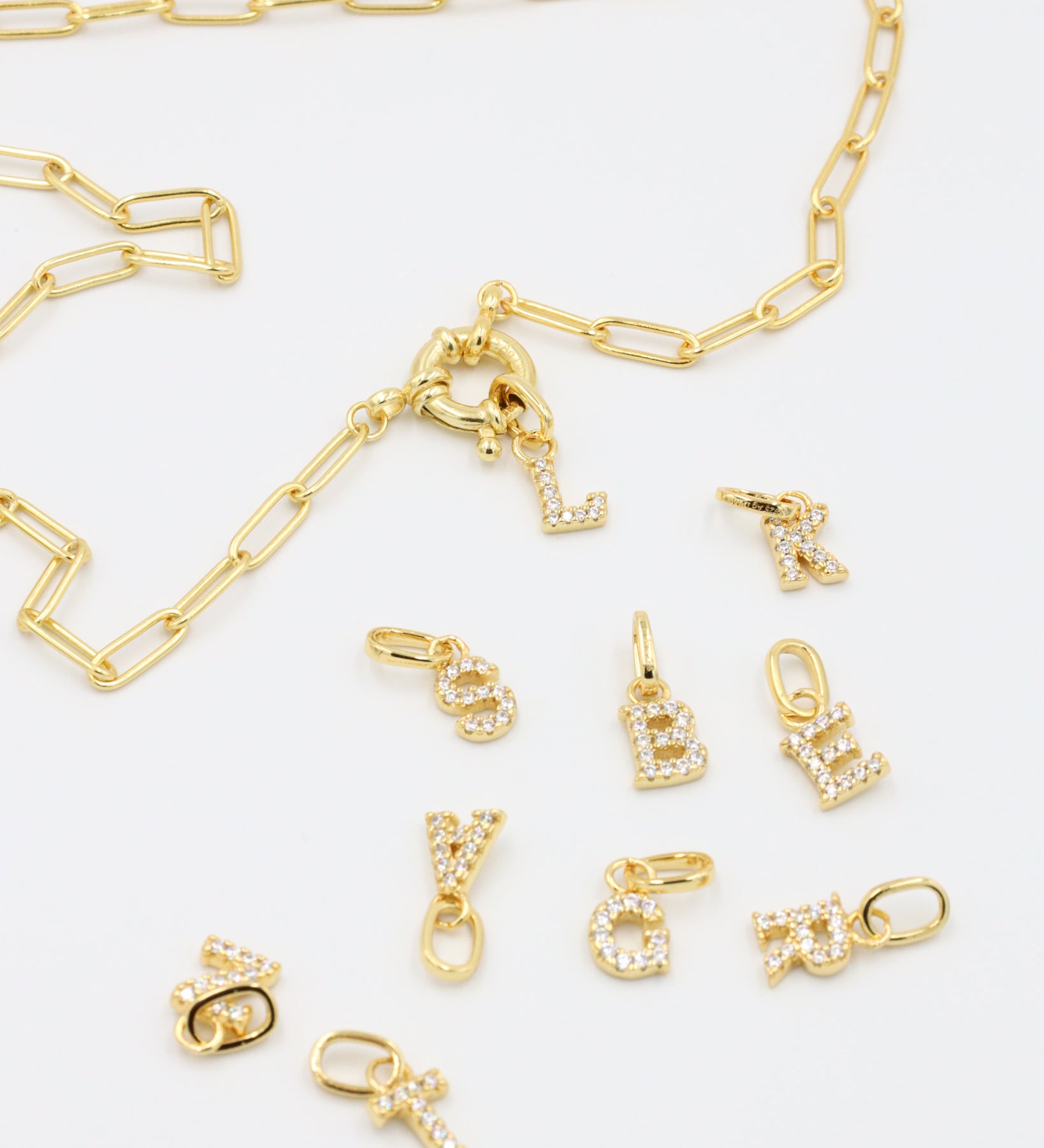 Gold chain with detachable letter pendants, showcasing the mix-and-match versatility of the gold-plated letter charms.