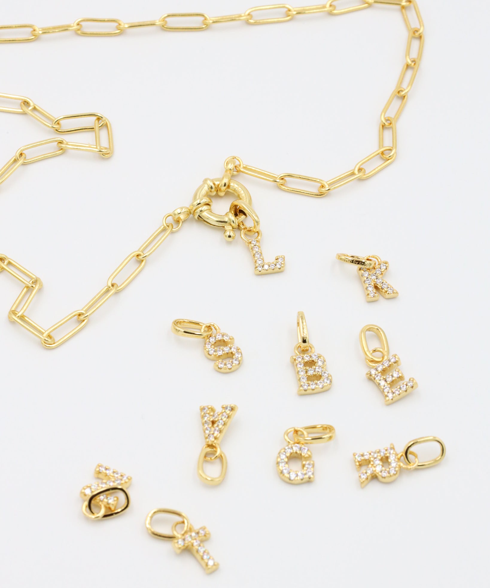 Gold chain with detachable letter pendants, showcasing the mix-and-match versatility of the gold-plated letter charms.