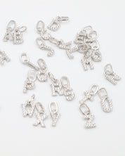 A set of sparkling letter pendants in sterling silver with zirconia, arranged in a group.