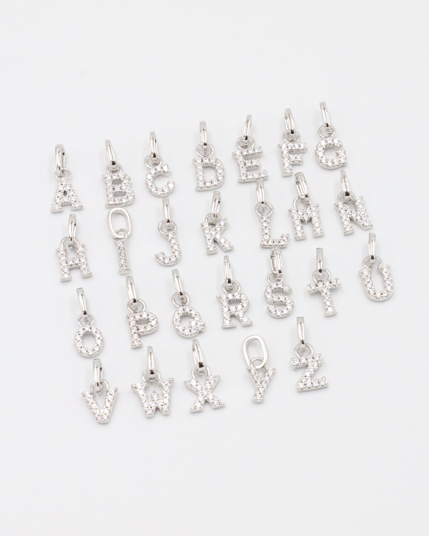 Full alphabet letter pendants in sterling silver, featuring dazzling zirconia stones.