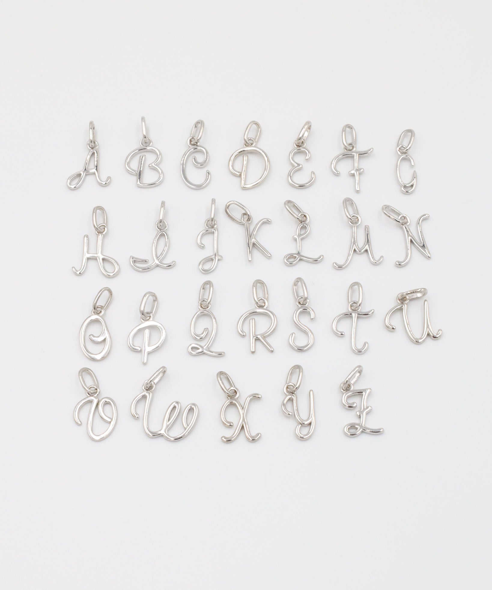 Full set of rhodium plated 925 sterling silver letter curve pendants displayed in alphabetical order.