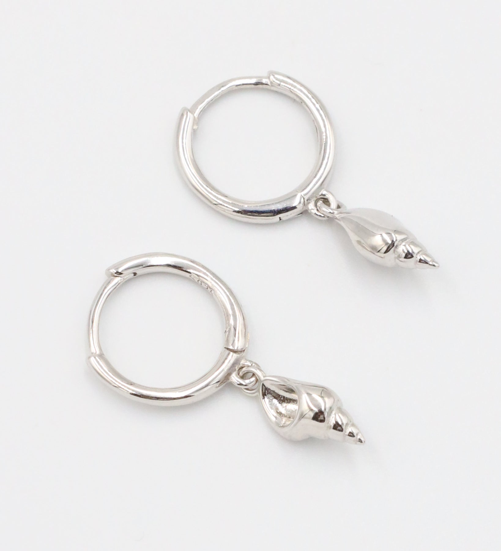 Pair of Maddy silver shell earrings in 925 sterling silver, featuring delicate shell pendants.