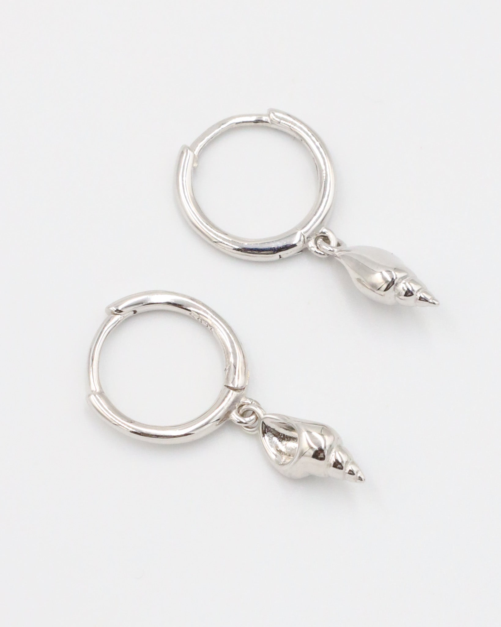 Pair of Maddy silver shell earrings in 925 sterling silver, featuring delicate shell pendants.
