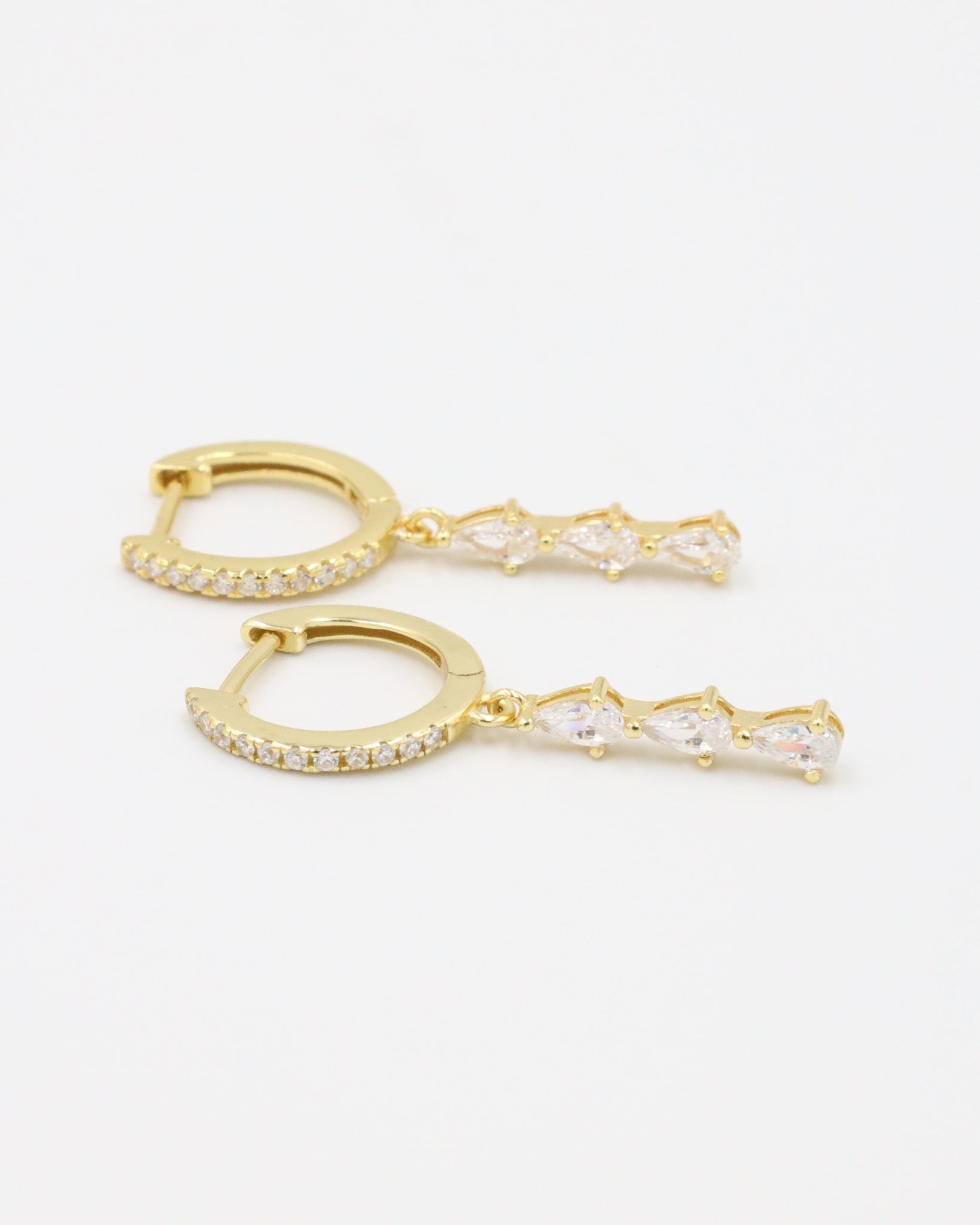 Side view of the Micah gold drop earring featuring four sparkling teardrop zirconia stones and a pavé hoop.